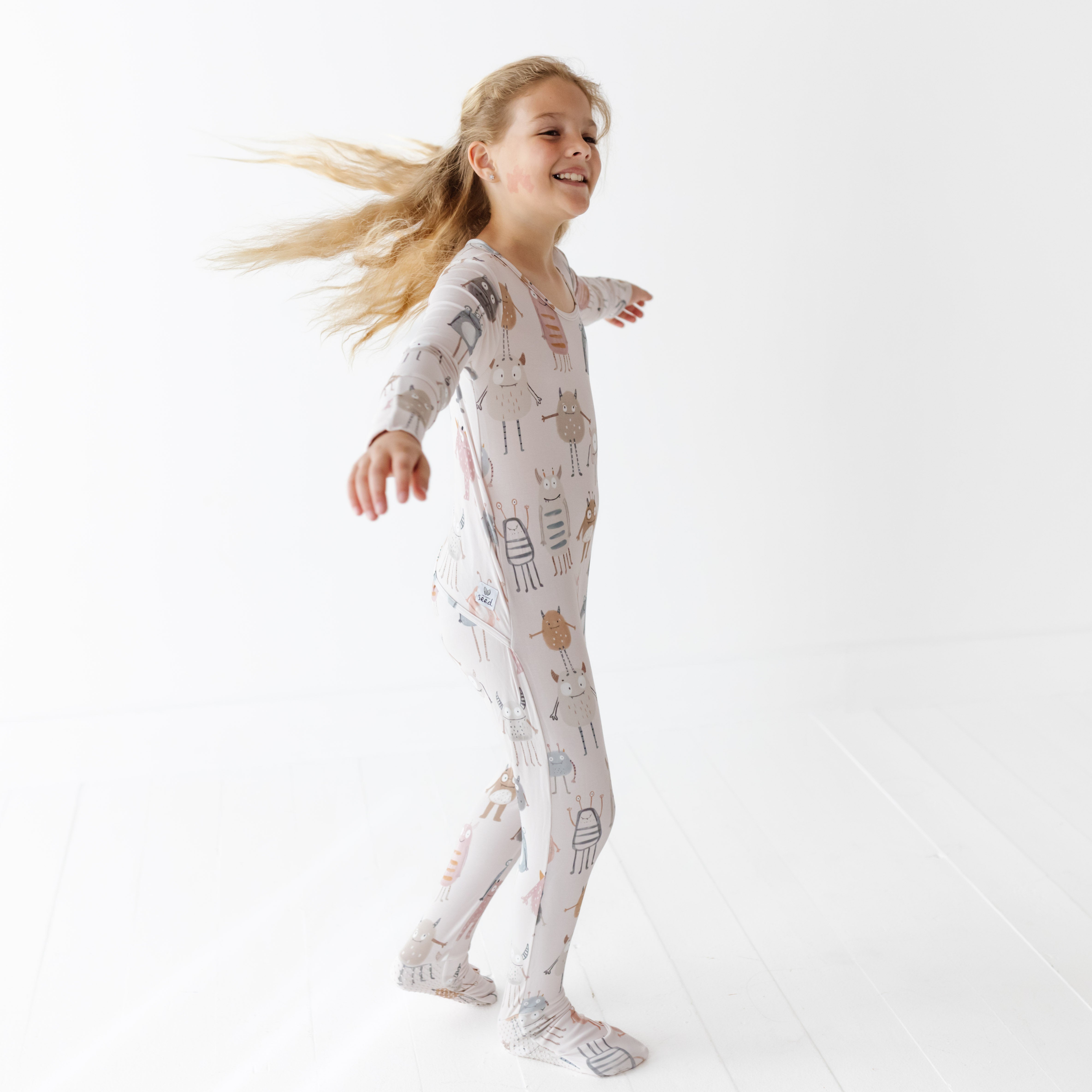 Child wearing a patterned onesie on a white background