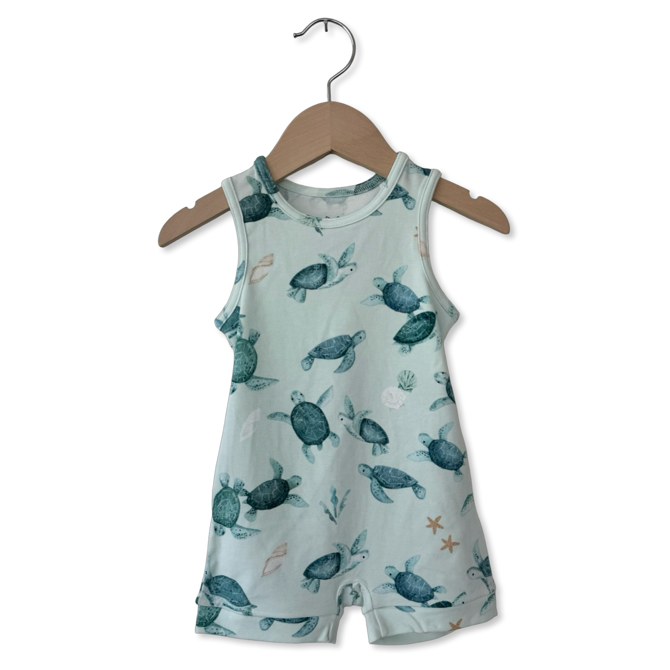 Children's sleeveless romper with turtle pattern on a hanger against a white background