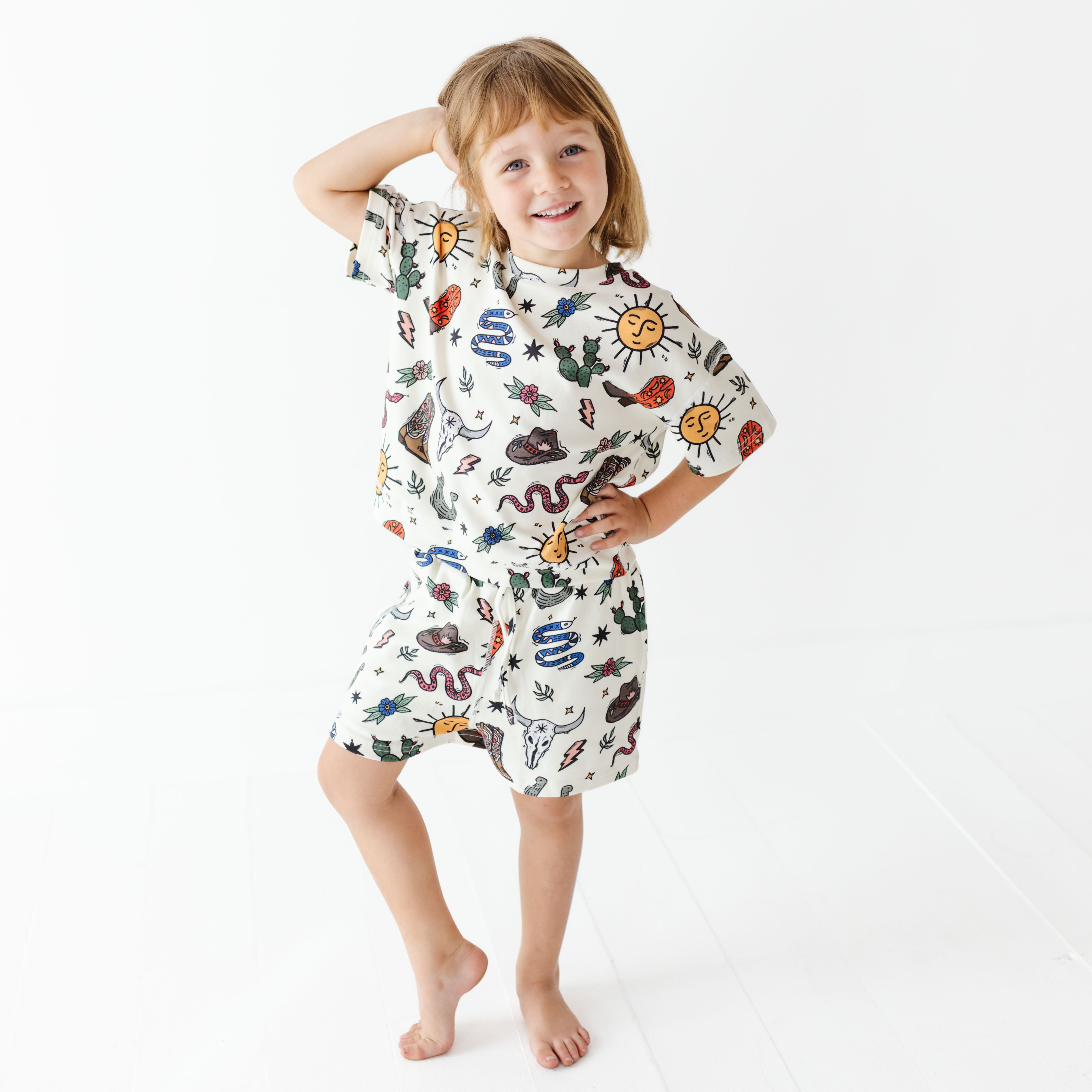 Child wearing a patterned outfit with cartoon animals on a white background