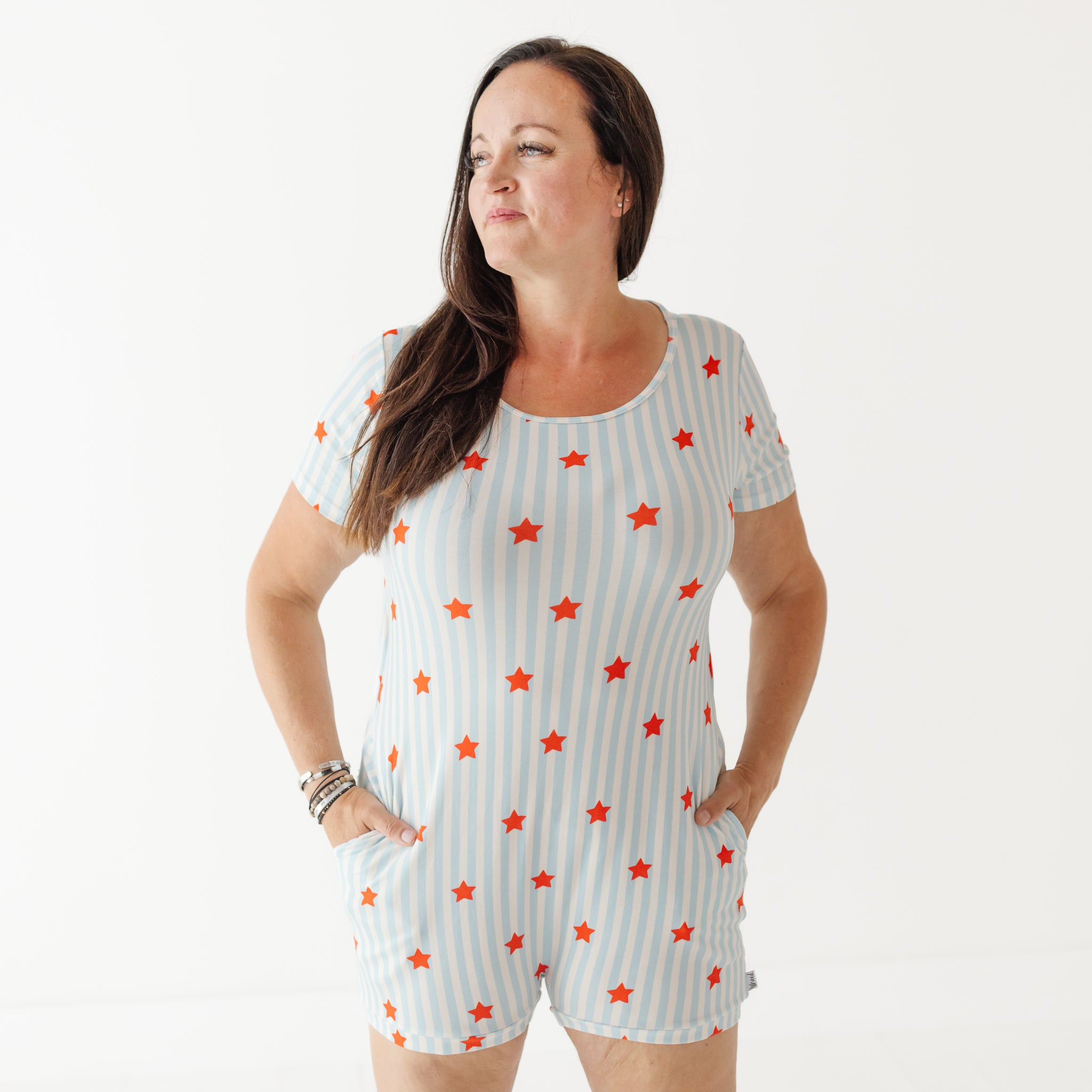 Woman wearing a white romper with red star patterns on a white background