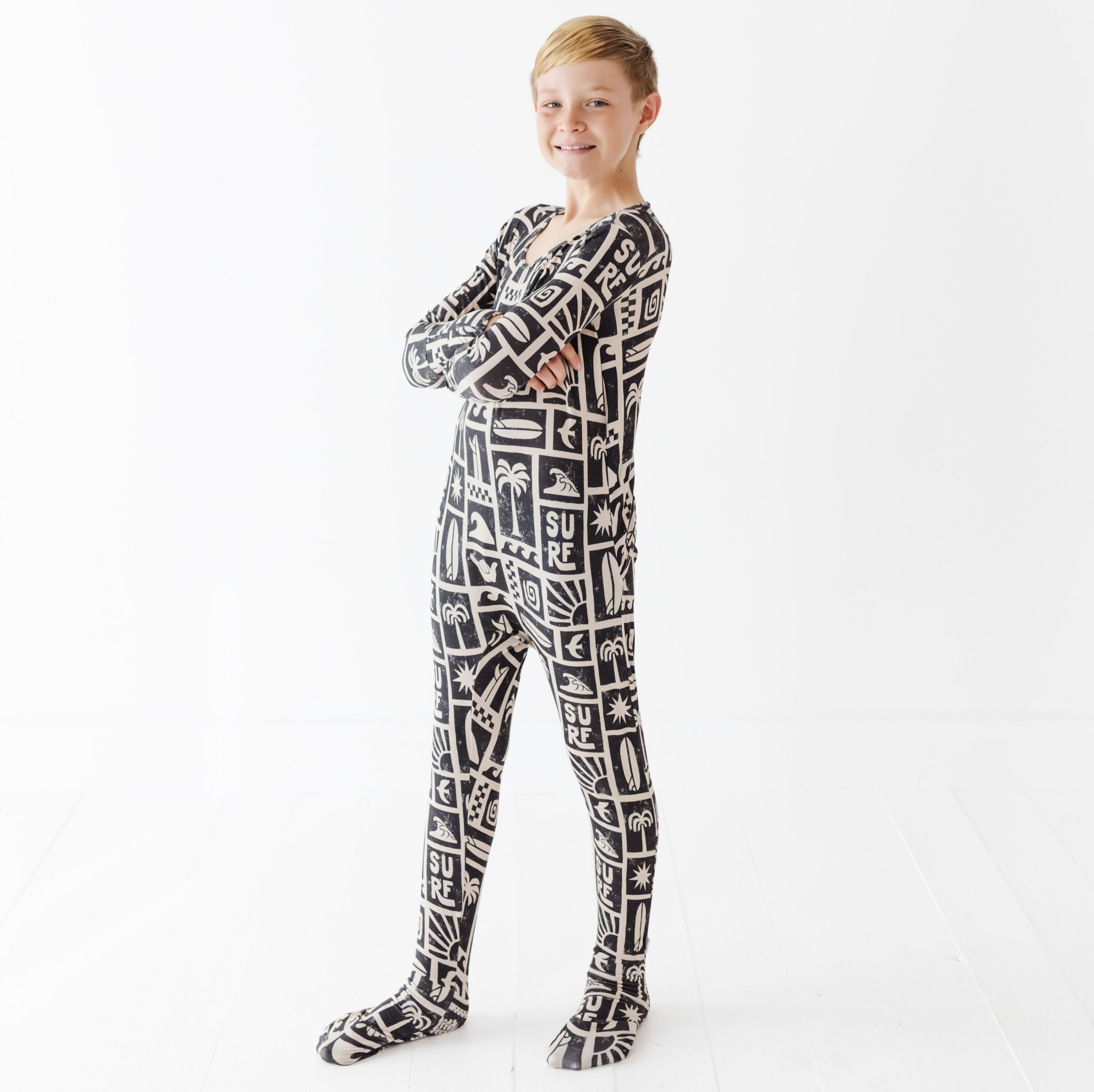 Child wearing a black and white patterned onesie on a white background
