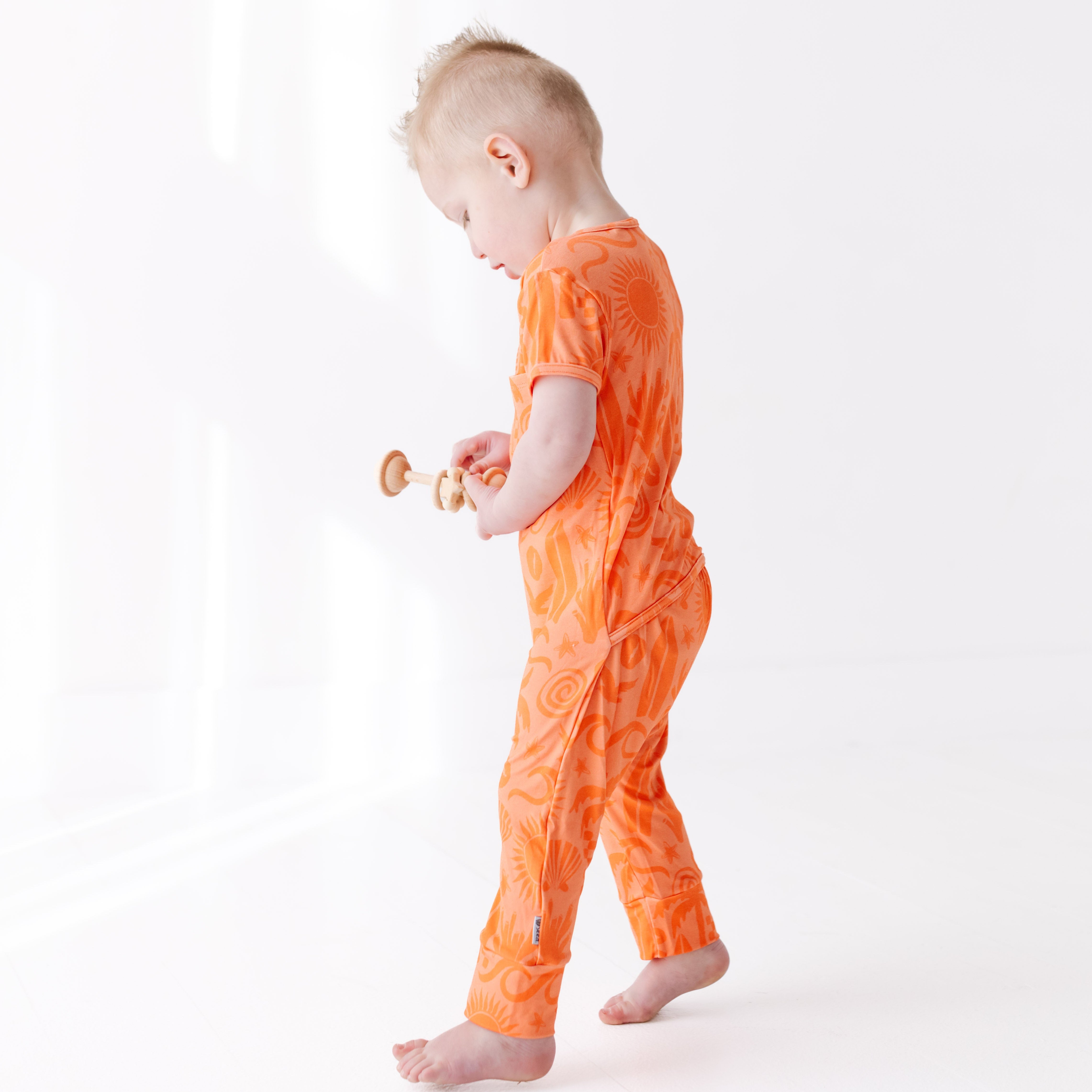 Child wearing an orange outfit on a white background