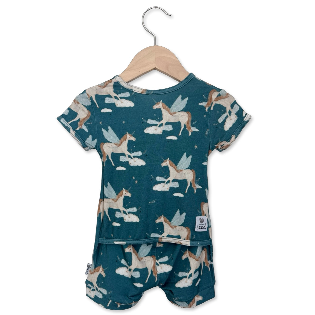 Children's outfit with unicorn pattern on a hanger against a white background
