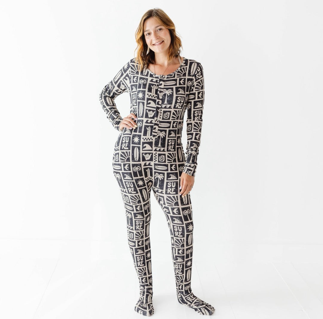 Woman wearing a black and white patterned onesie on a white background
