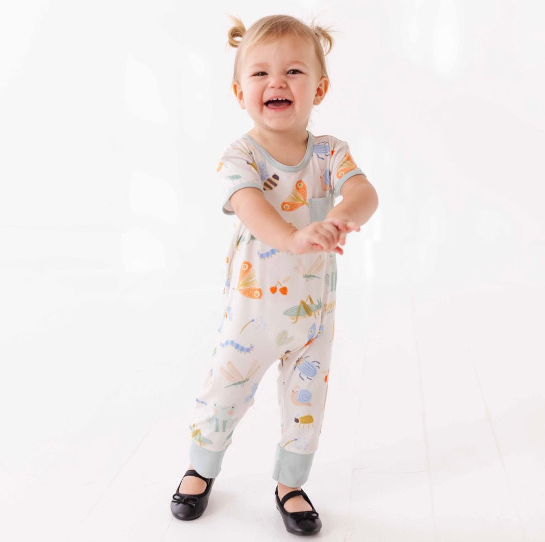 Child wearing a patterned onesie on a white background