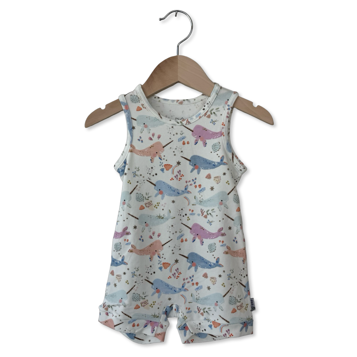 Children's romper with whale pattern on a hanger against a white background