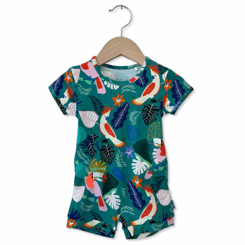 Children's outfit with tropical bird pattern on a hanger against a white background