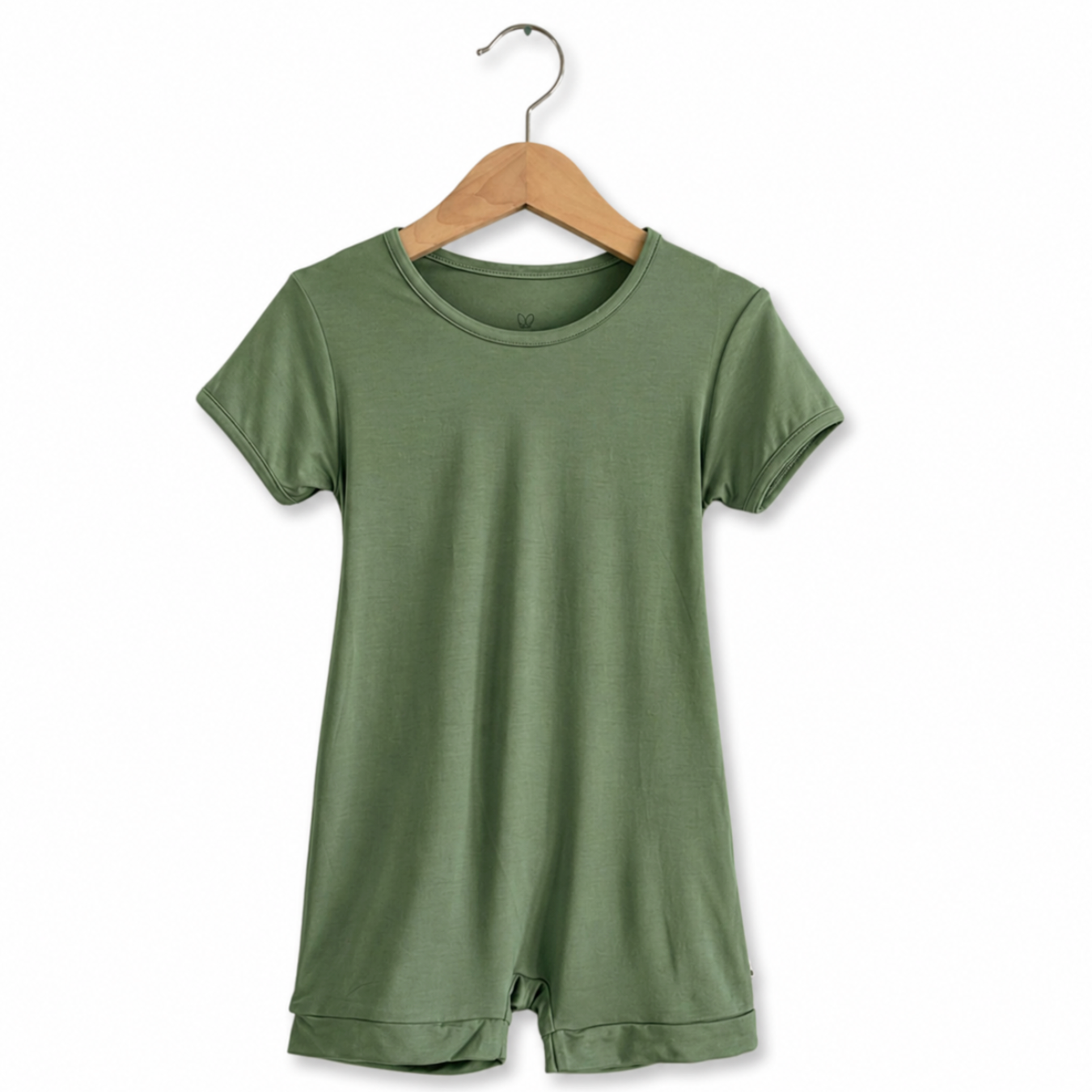 Green romper on a wooden hanger against a white background