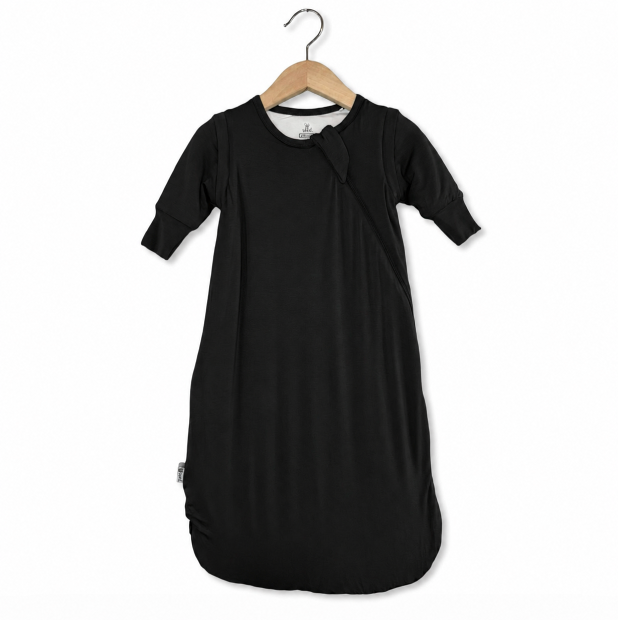 Black baby sleeping bag on a wooden hanger against a white background
