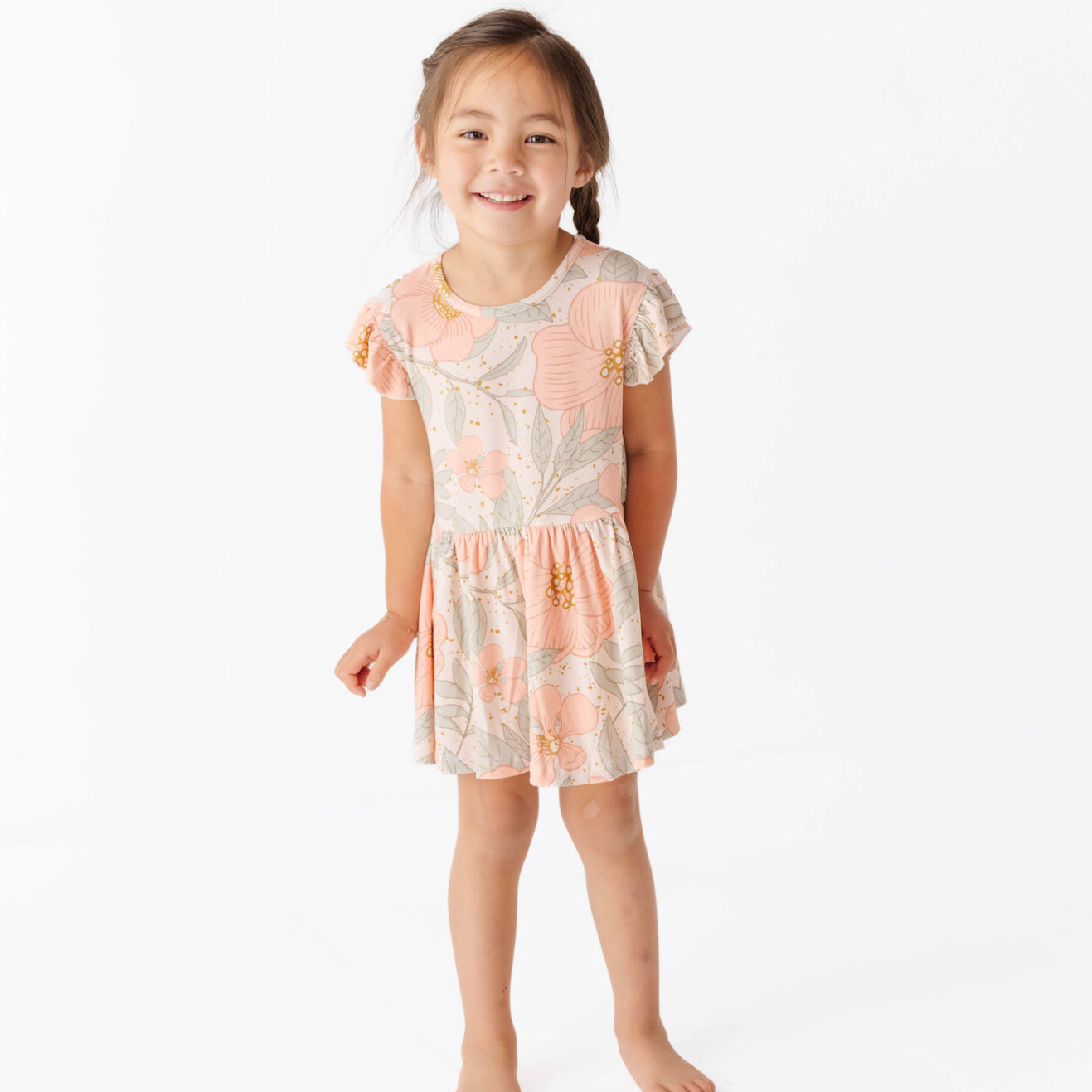 Young girl wearing a floral dress on a white background