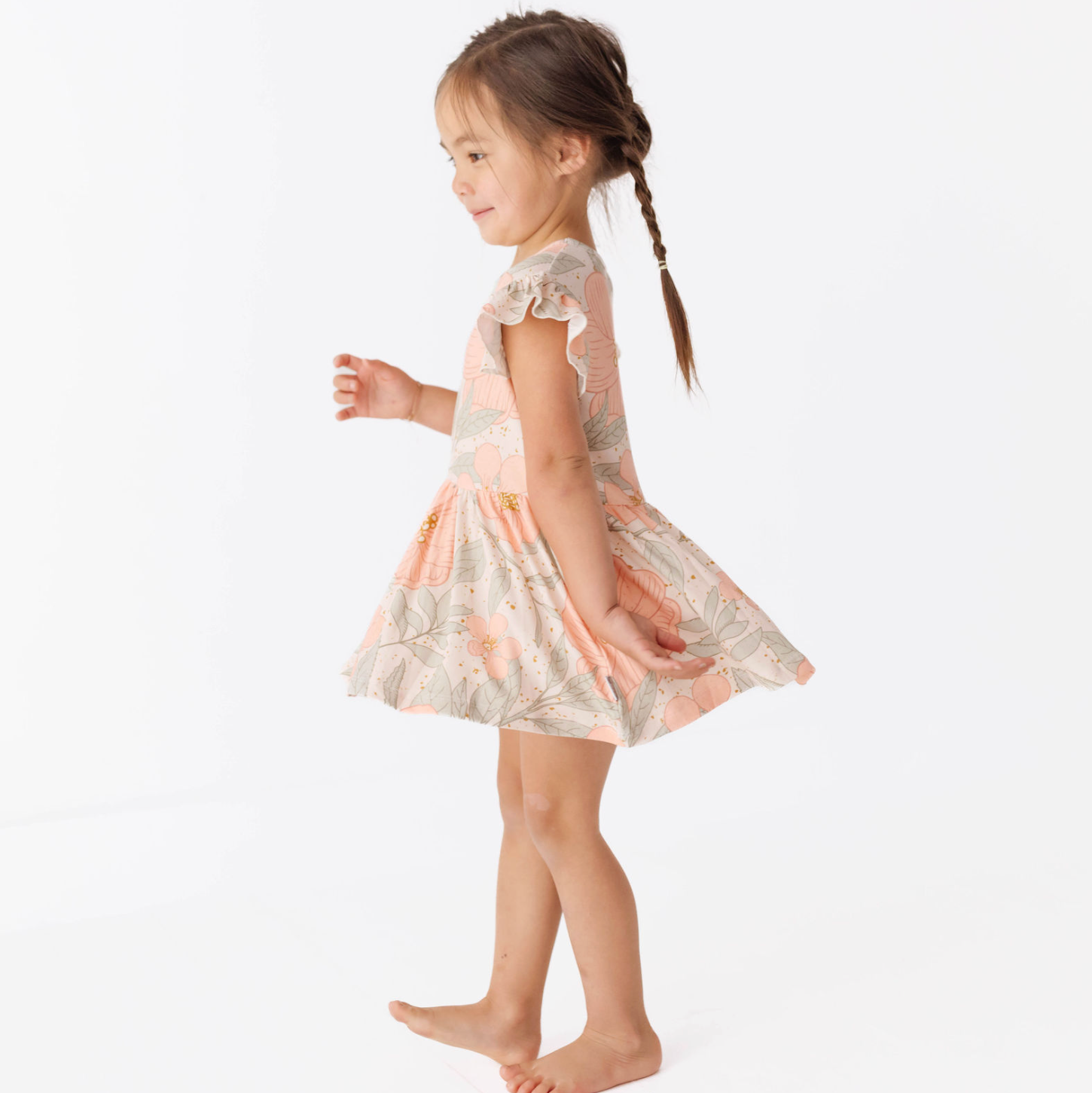 Young girl wearing a floral dress on a white background
