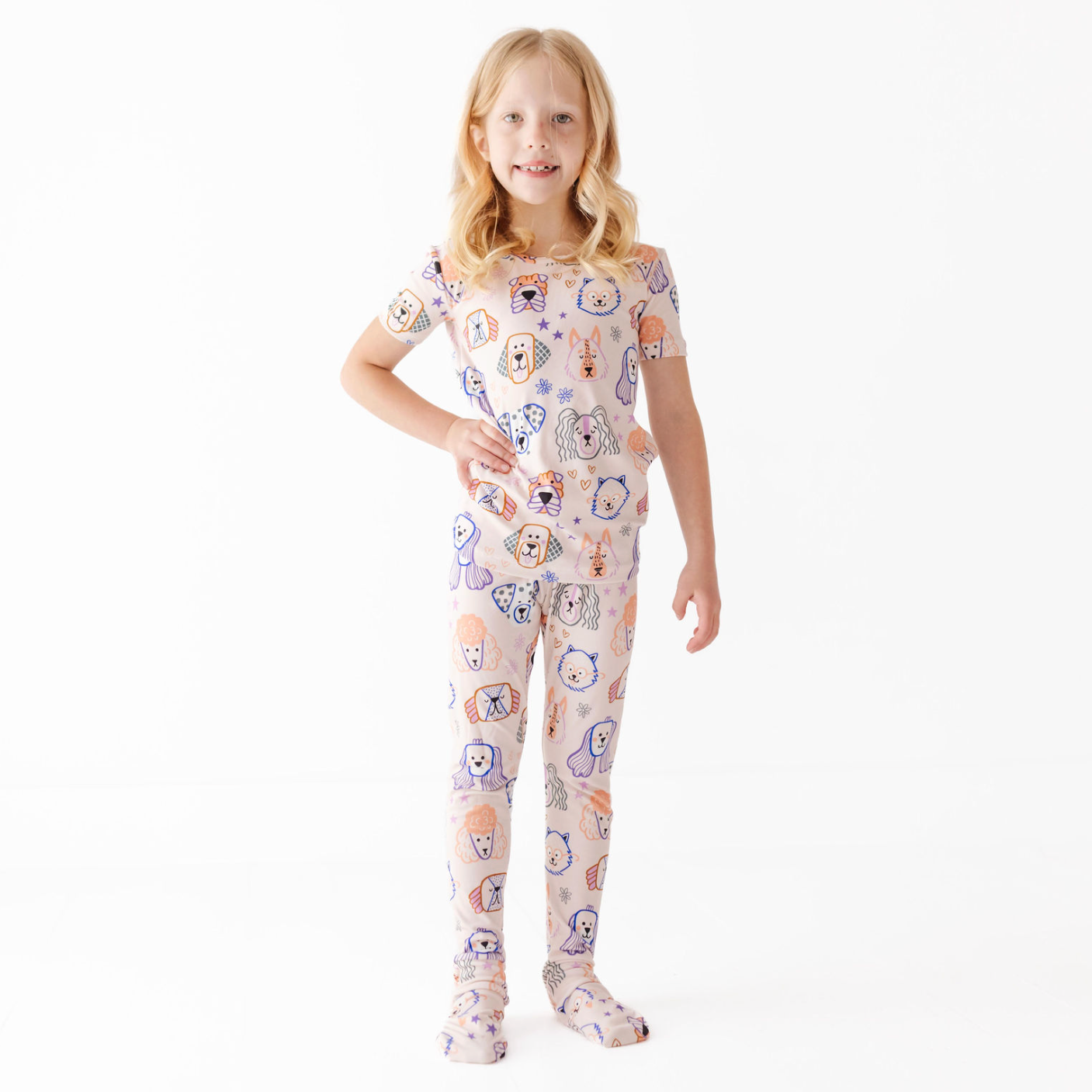 Child wearing a pajama set with animal prints on a white background