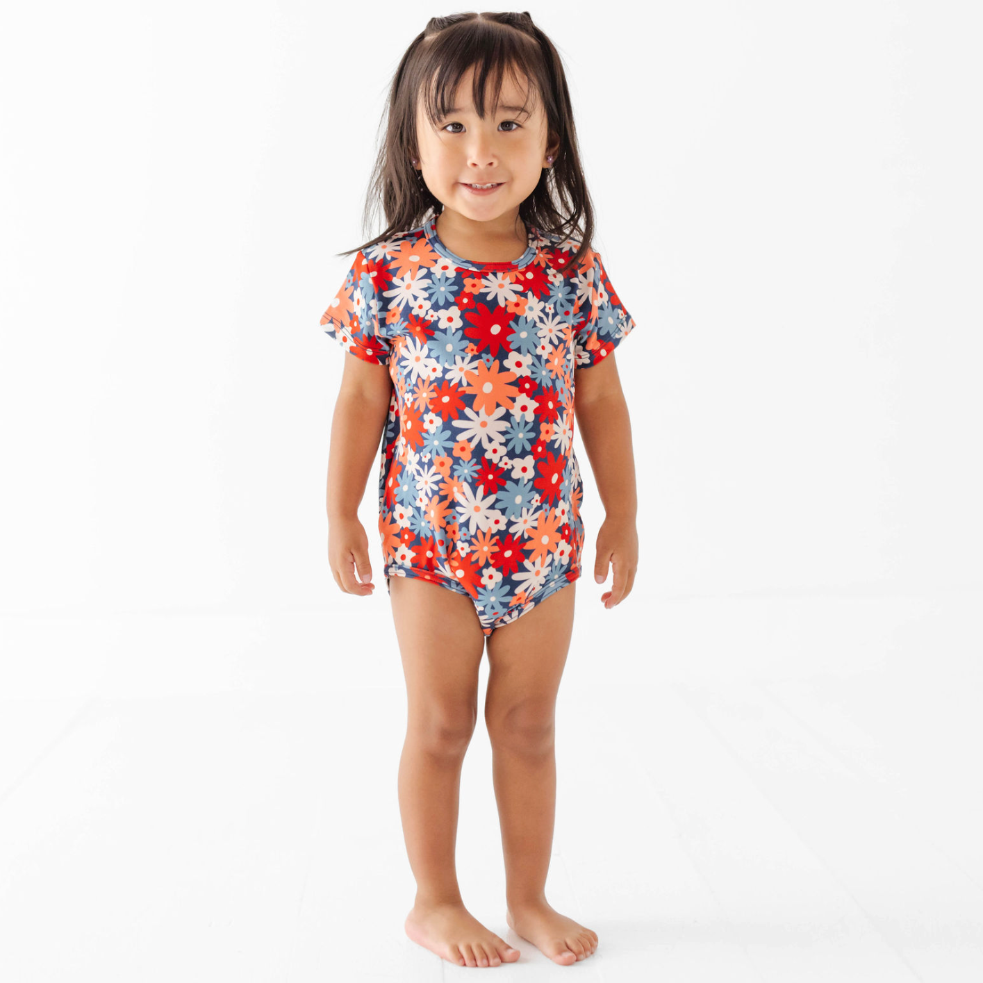 Child wearing a colorful floral swimsuit on a white background