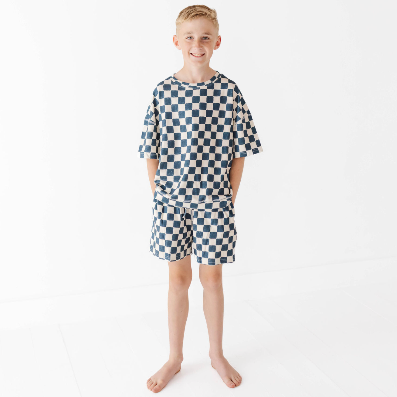 Child wearing a blue and white checkered outfit on a white background