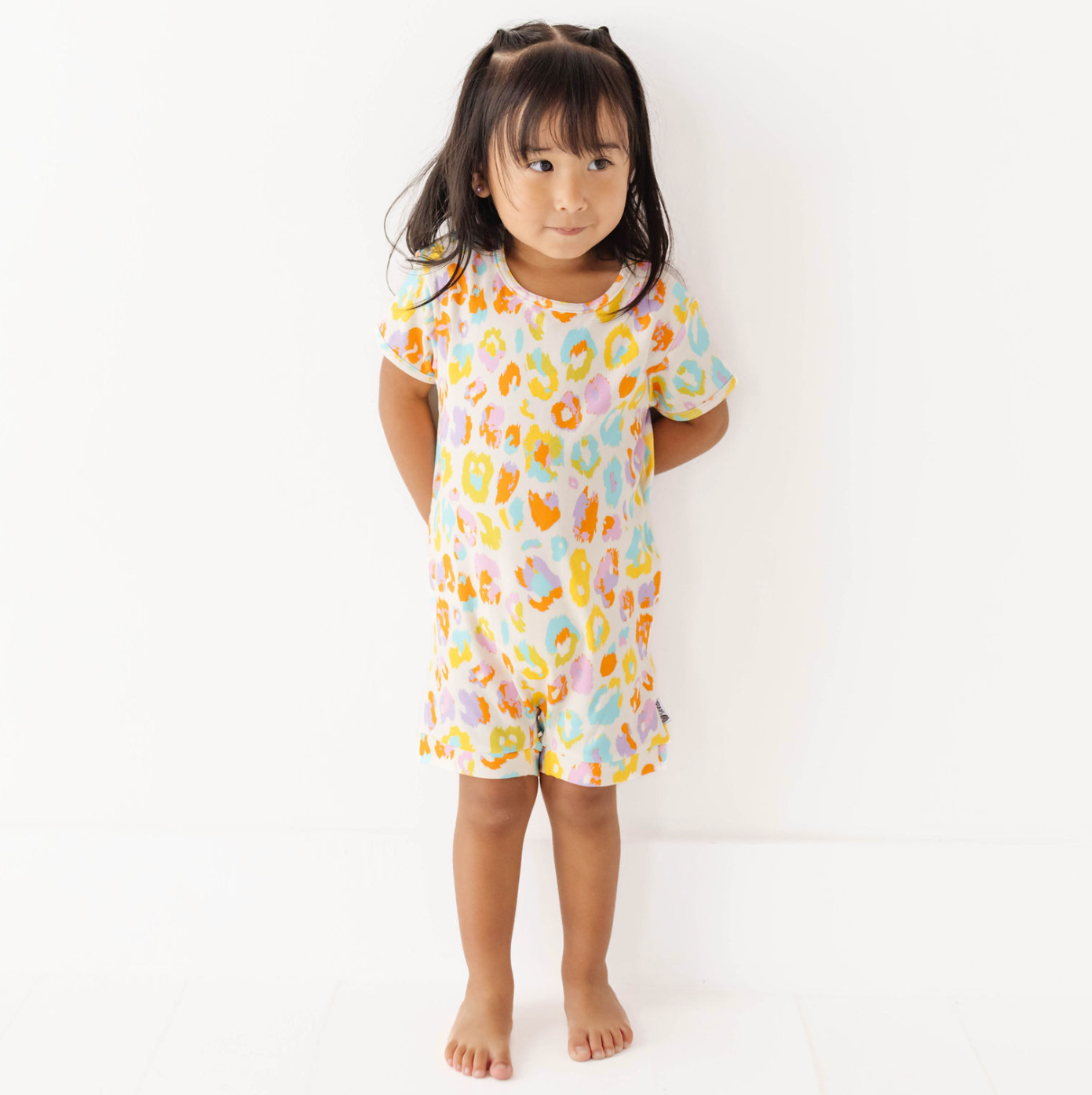 Child wearing a colorful pajama set on a white background