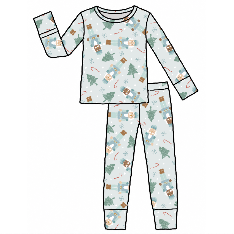A flat vector illustration of a two-piece pajama set featuring a long-sleeve top and matching pants with a winter holiday print on a light blue-gray background.