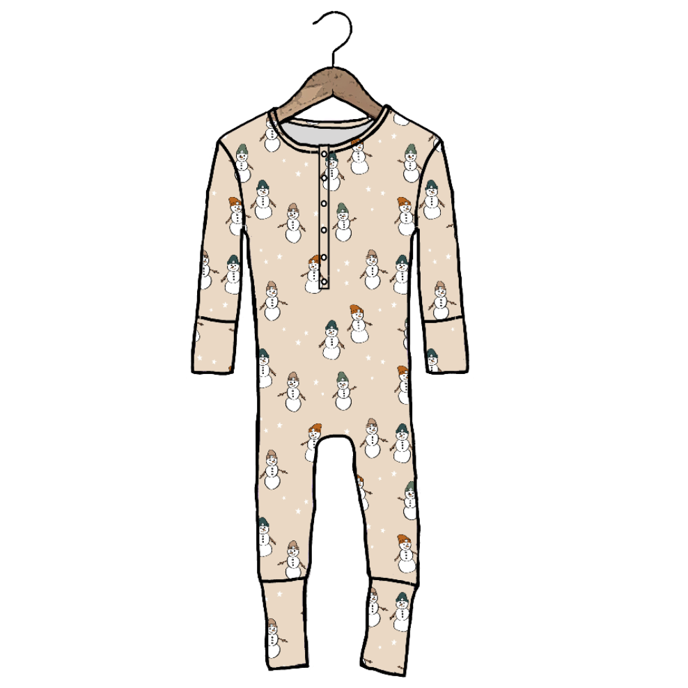A long-sleeve baby jumpsuit in beige with an all-over snowman print, hanging on a wooden hanger against a plain white background.