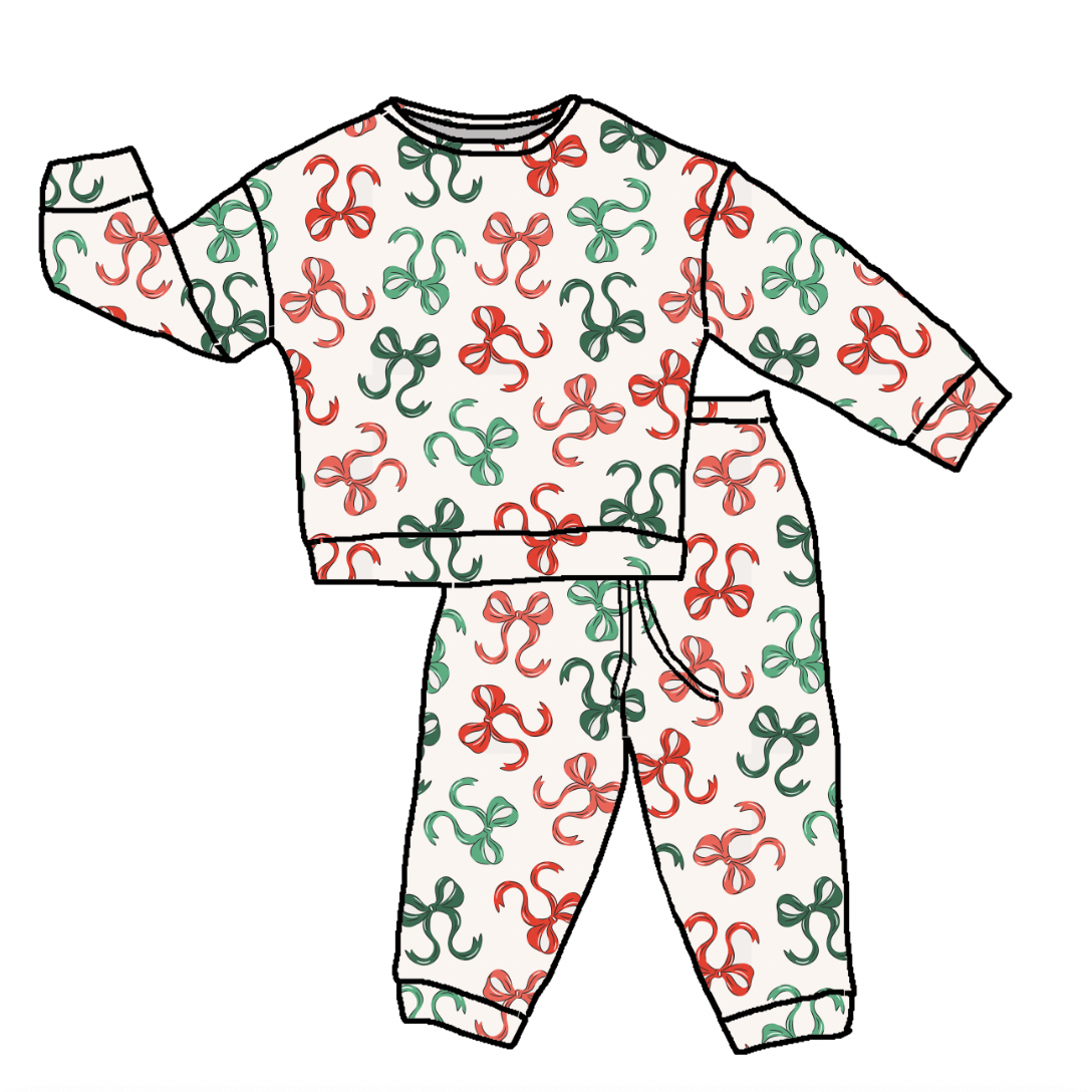 A flat illustration of a two-piece children's pajama set, featuring a long-sleeve top and matching pants. The set has an off-white background with a repeating pattern of red and green abstract ribbon-like bows, outlined in black.