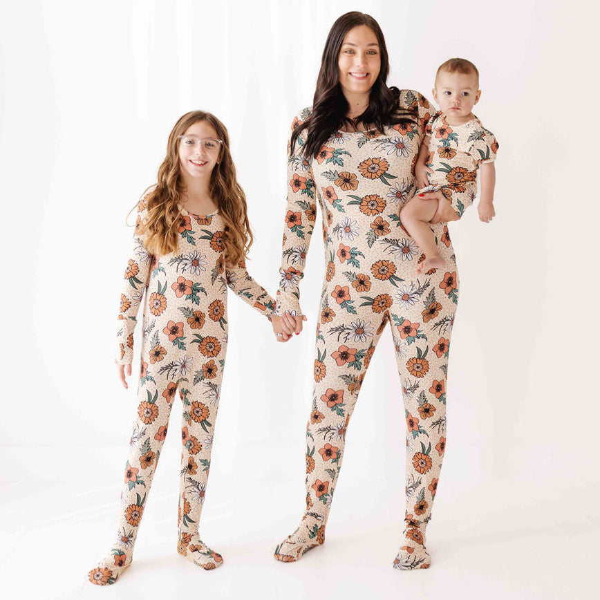 Family of three wearing matching floral pajamas on a white background