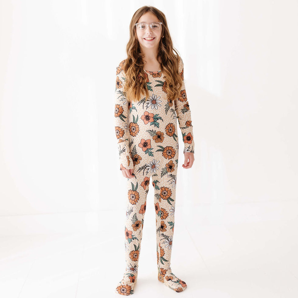 Person wearing a floral patterned onesie on a white background