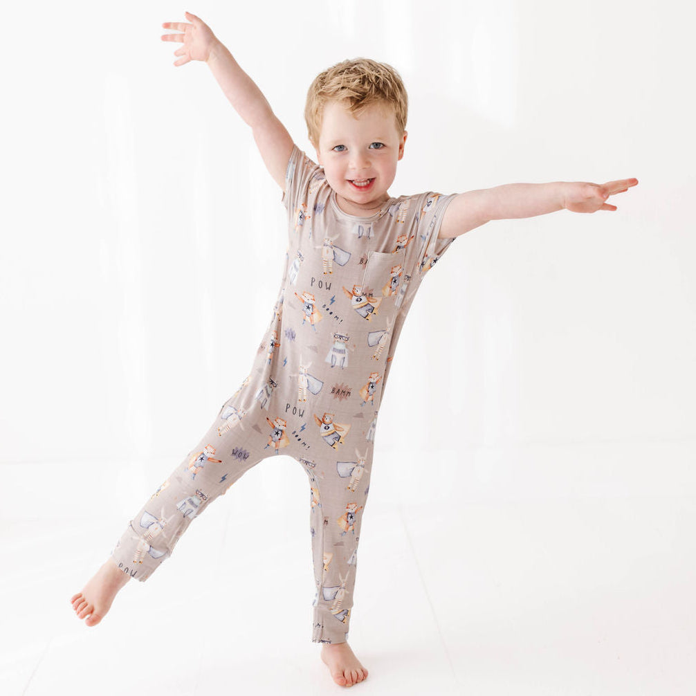 Child wearing a patterned onesie on a white background