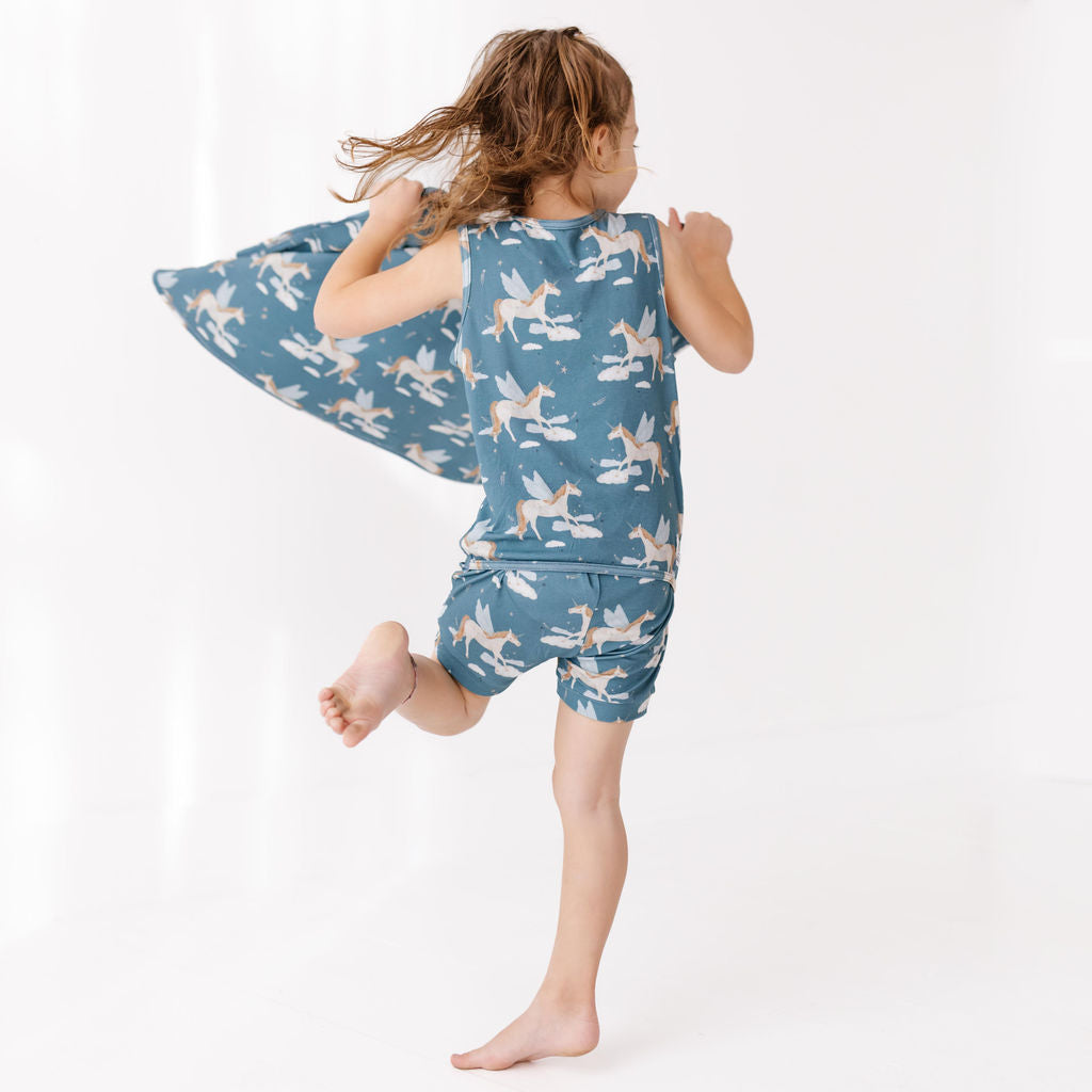 Child wearing a blue pajama set with cloud and moon pattern on a white background