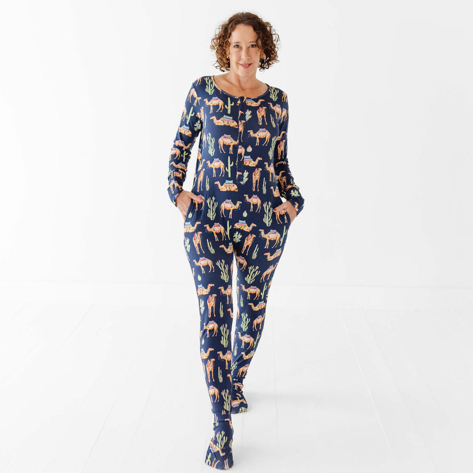 Woman wearing a navy blue onesie with animal pattern on a white background