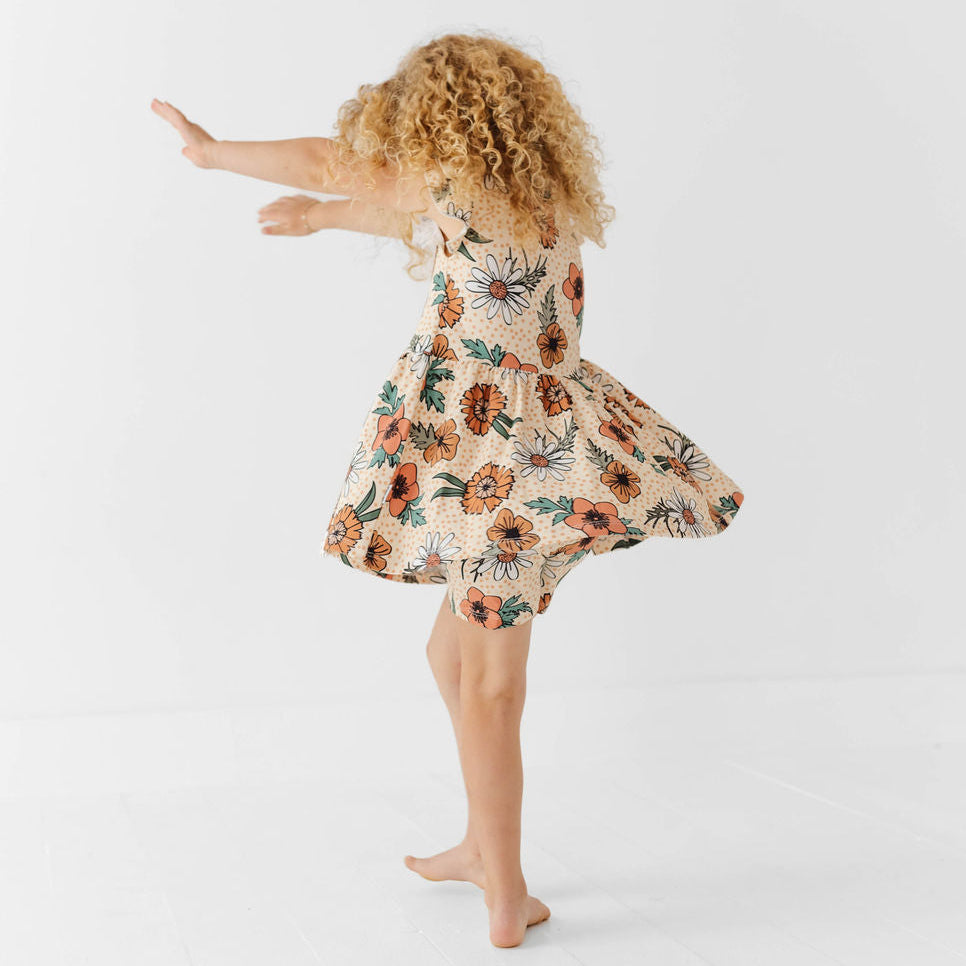 Child wearing a floral dress on a white background