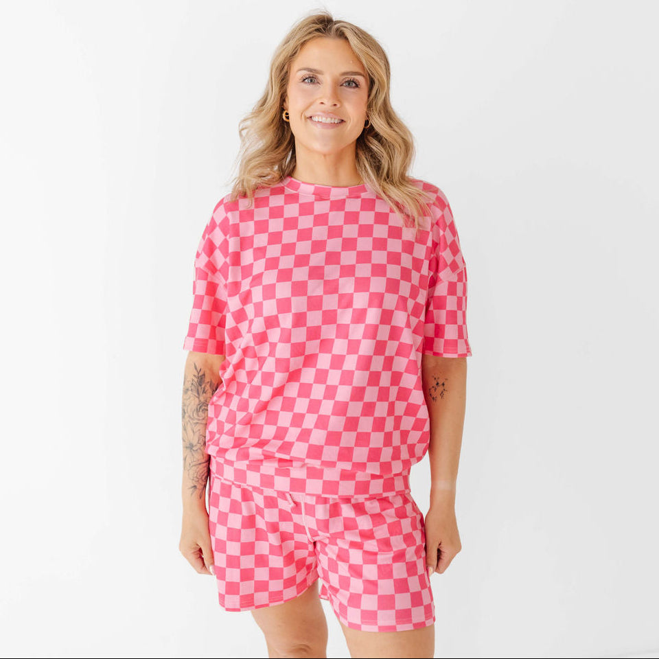 Woman wearing a pink checkered outfit on a white background