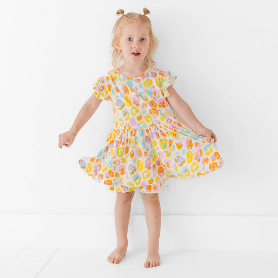 Young girl wearing a colorful floral dress on a white background