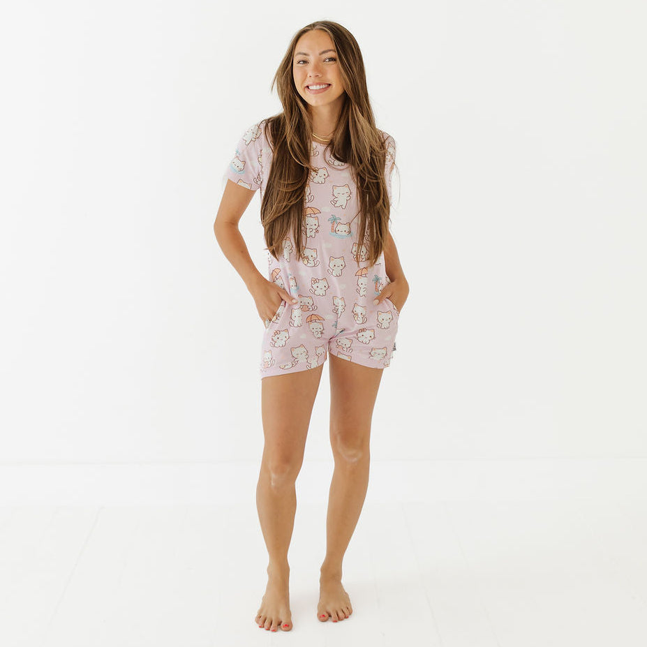 Woman wearing a pink pajama set with cartoon characters on a white background