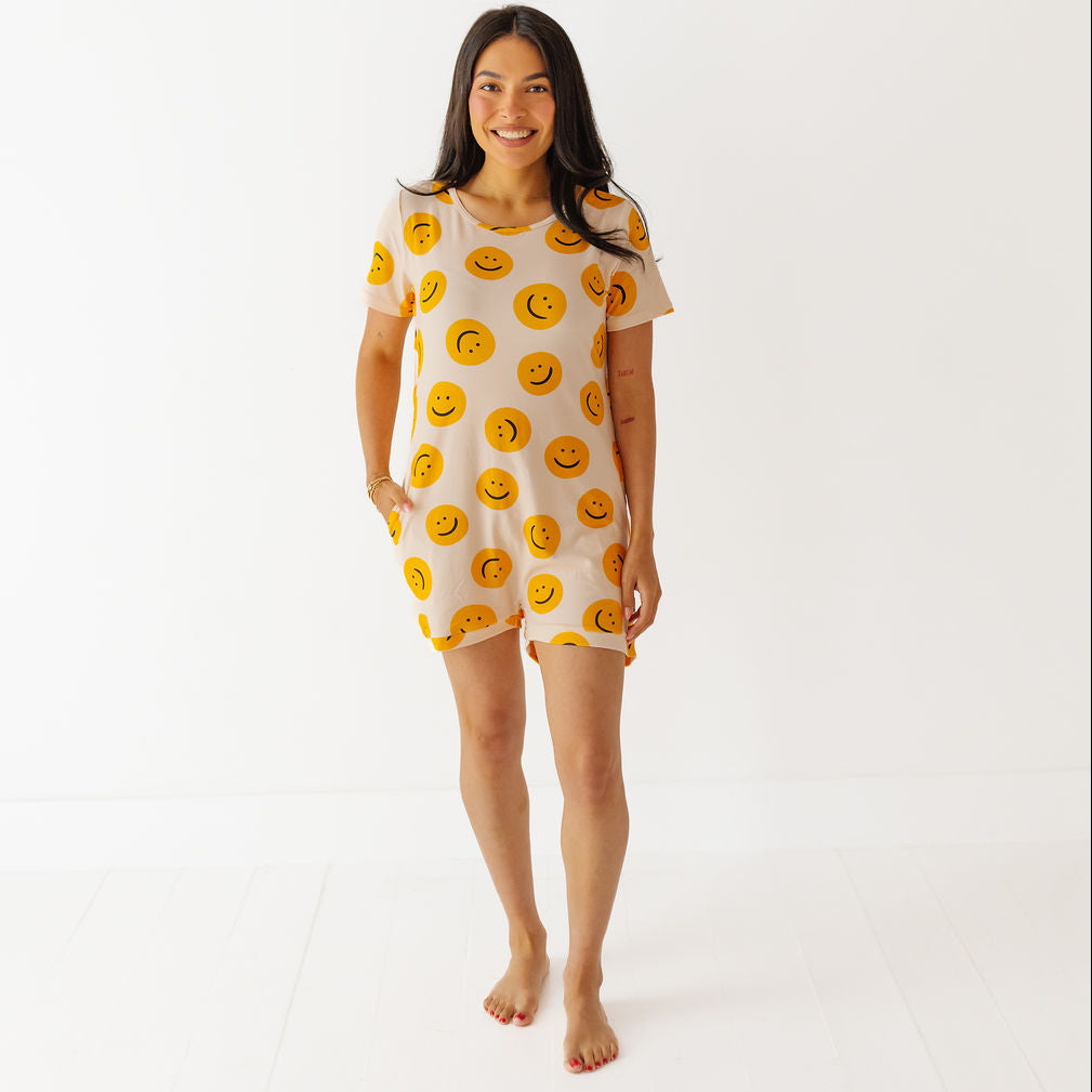 Woman wearing a short-sleeve dress with smiley face pattern on a white background