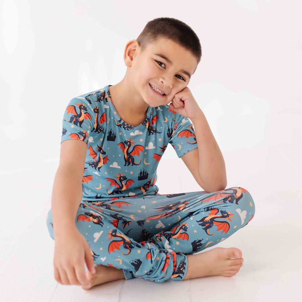 Child wearing a blue pajama set with dragon design on a white background