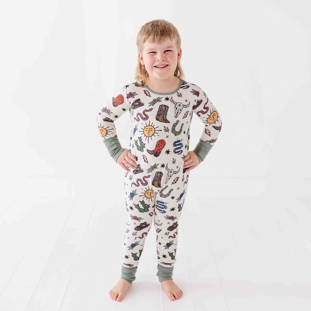 Child wearing a colorful pajama set with various designs on a white background