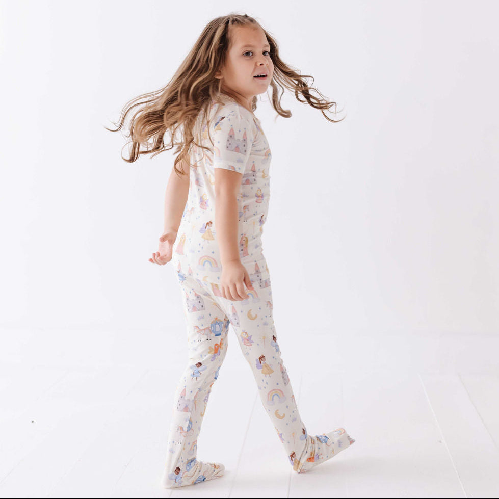 Child wearing a patterned pajama set on a white background