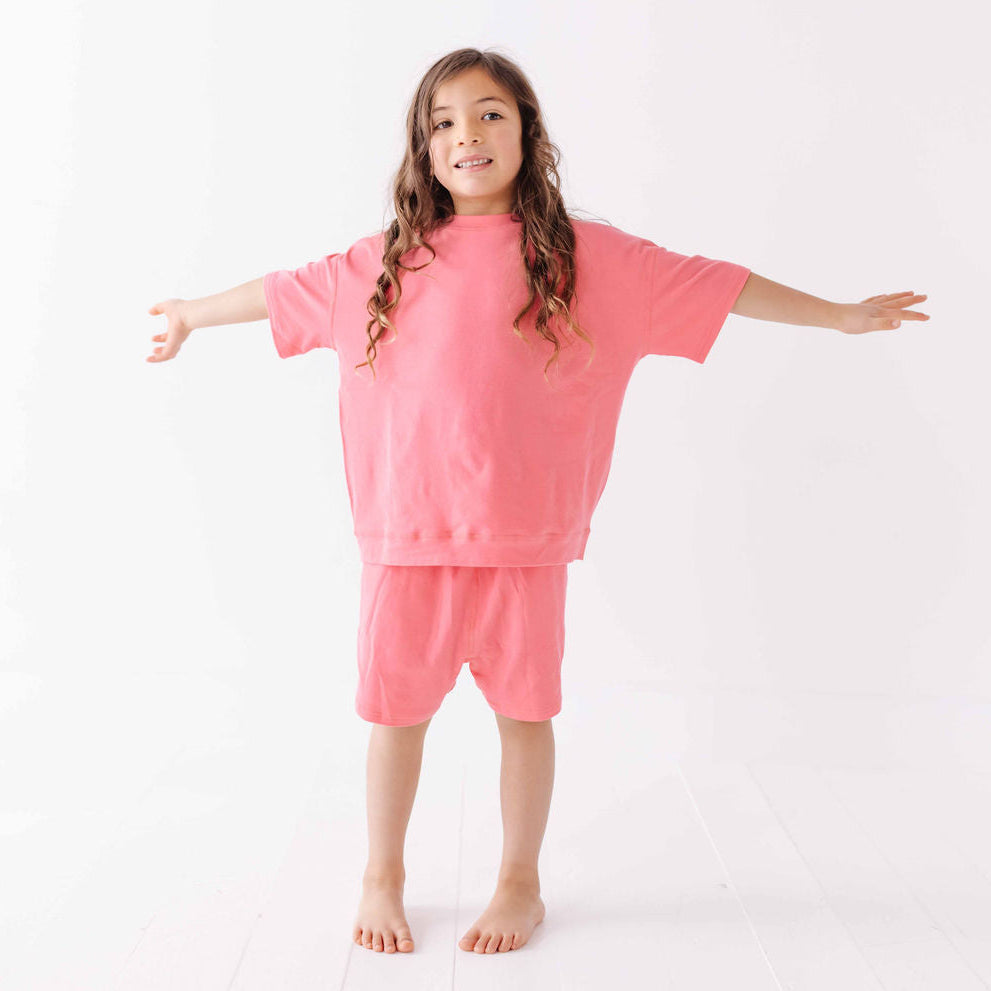 Child wearing a pink outfit on a white background