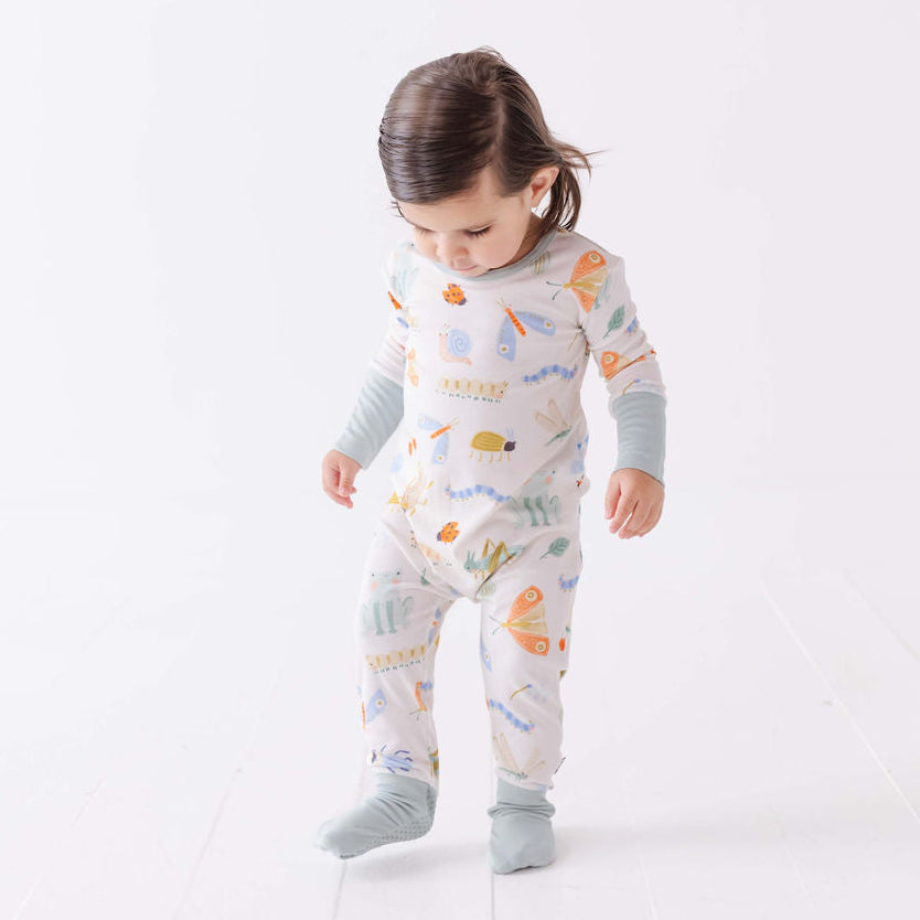 Child wearing a colorful onesie with a white background